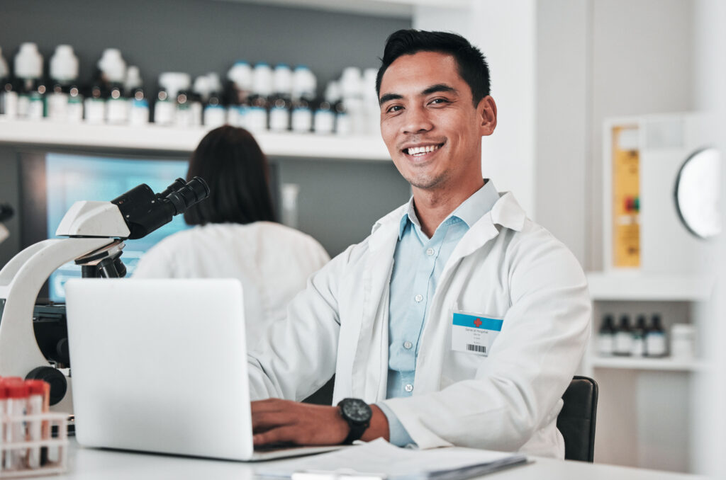 doctor smiling on in front of his computer in an EHR practice management software