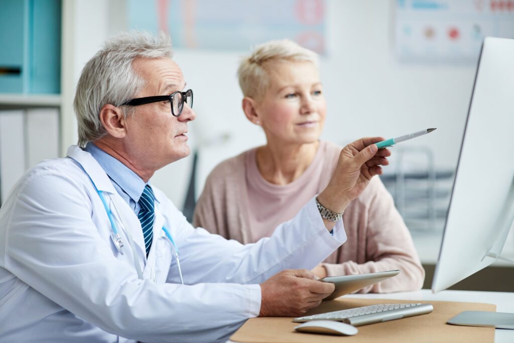 doctor showing healthcare worker electronic health records (EHR)