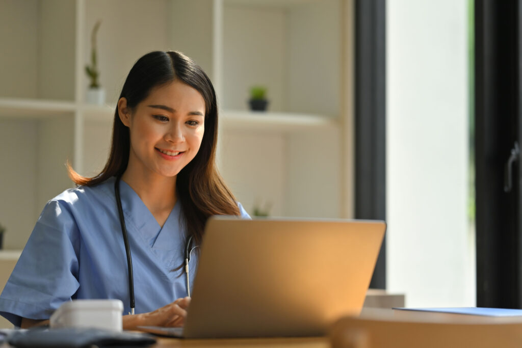 smiling female doctor reading electronic health records (EHR