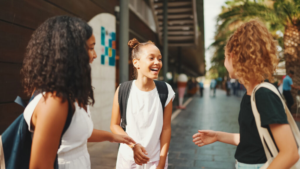 three girls friends pre-teenage stand on the street therapy activities